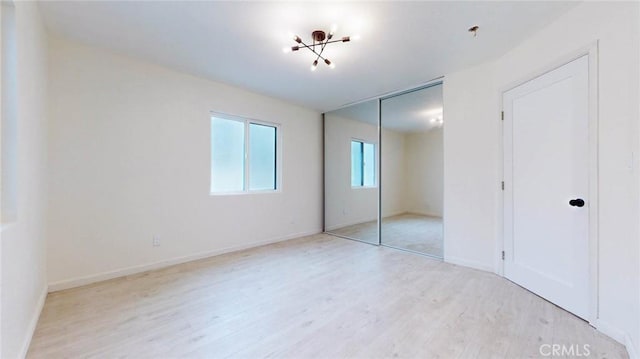 unfurnished bedroom with a closet, light wood-type flooring, and baseboards