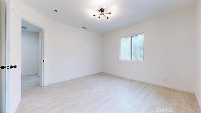 empty room featuring light wood finished floors, baseboards, and visible vents