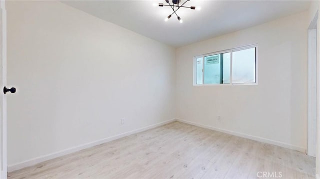 unfurnished room with light wood-type flooring and baseboards