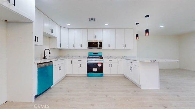 kitchen with a peninsula, stainless steel appliances, light countertops, white cabinetry, and pendant lighting