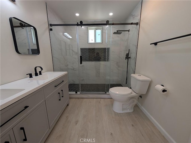 full bathroom featuring toilet, a shower stall, a sink, and wood finished floors