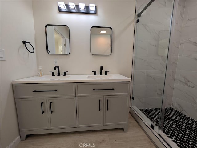 full bathroom featuring a stall shower, a sink, baseboard heating, and double vanity