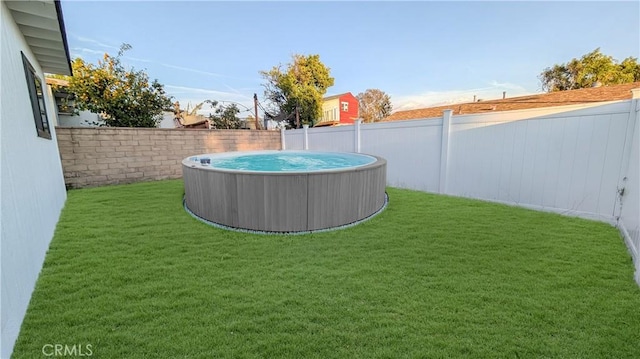 view of yard featuring a hot tub and a fenced backyard