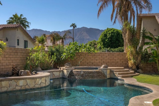 view of swimming pool with a mountain view and an in ground hot tub