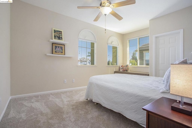 bedroom featuring multiple windows, light carpet, and ceiling fan