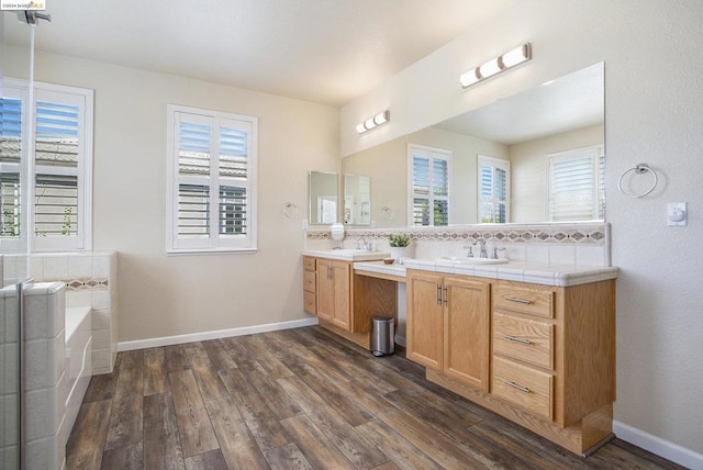 bathroom featuring wood-type flooring, a washtub, and vanity