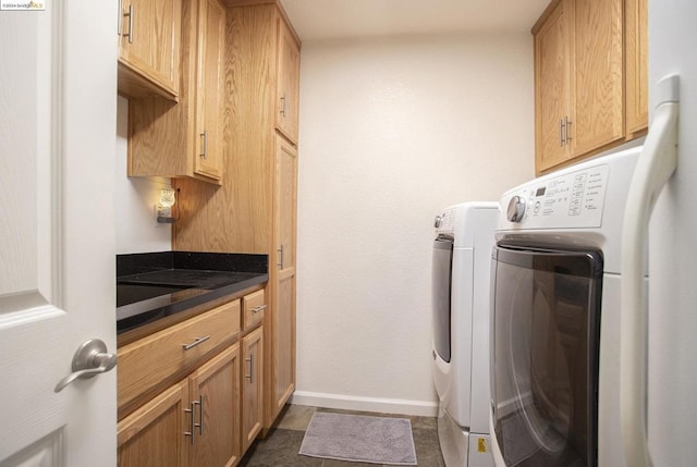 washroom featuring cabinets and washer and clothes dryer