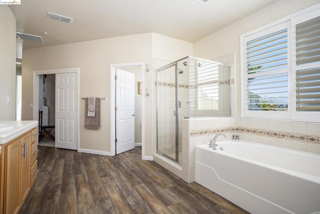 bathroom with vanity, hardwood / wood-style flooring, and shower with separate bathtub