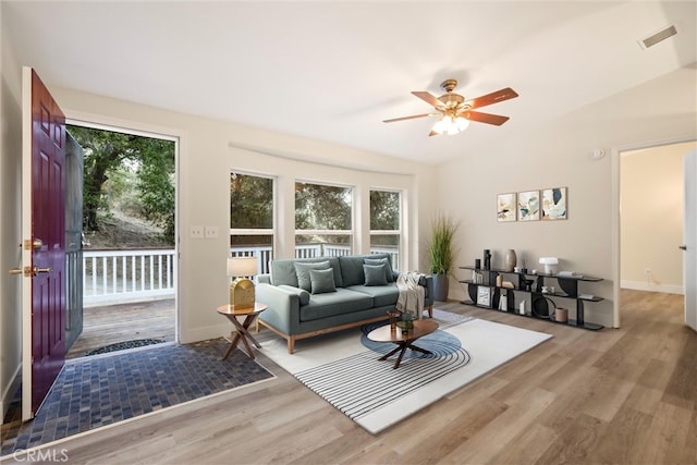 living room featuring light wood-type flooring, ceiling fan, and a healthy amount of sunlight