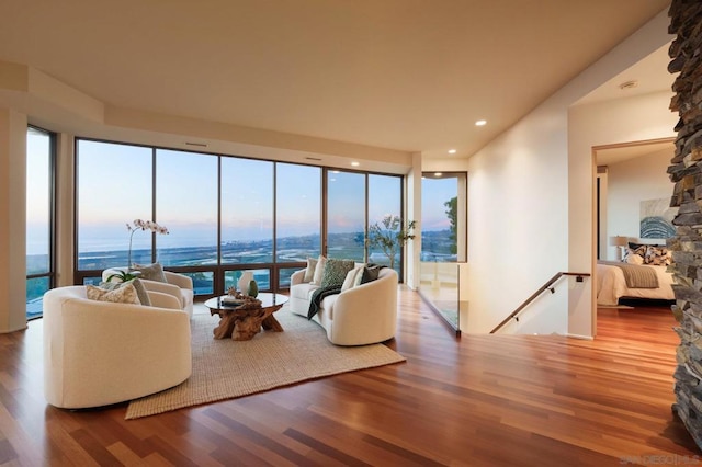 living room with a water view, wood-type flooring, and plenty of natural light