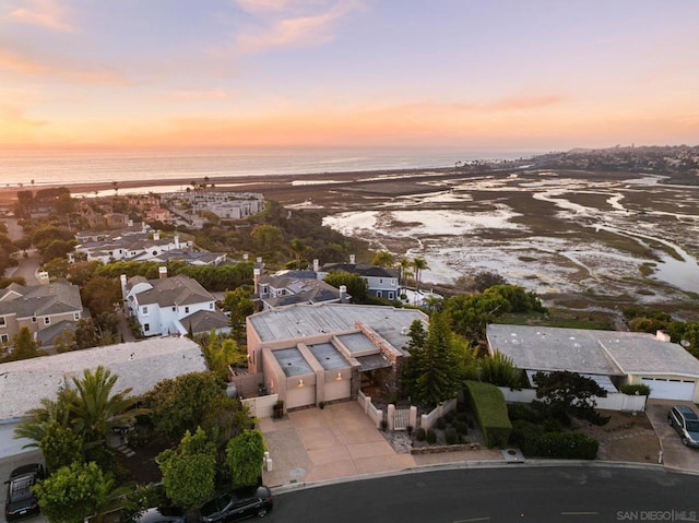 aerial view at dusk featuring a water view