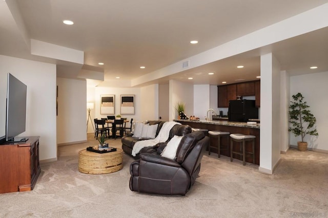 carpeted living room featuring sink