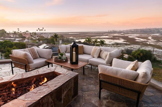 patio terrace at dusk with an outdoor living space with a fire pit