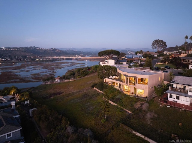 aerial view at dusk featuring a water view