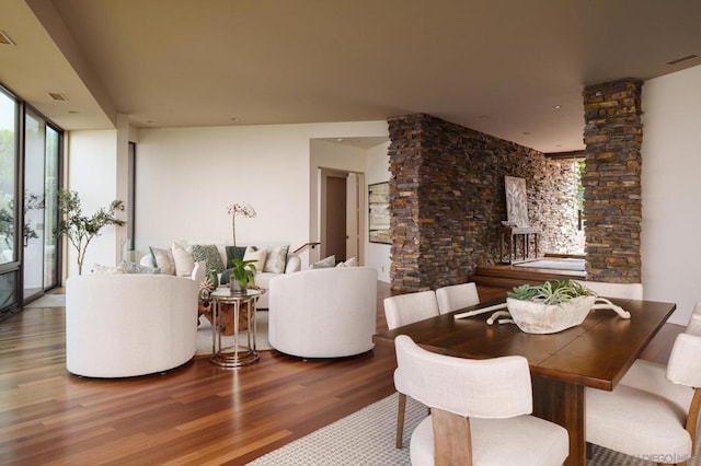 dining space featuring hardwood / wood-style flooring and decorative columns