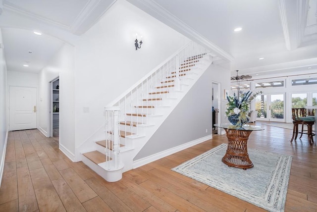 staircase featuring hardwood / wood-style flooring, ornamental molding, and french doors