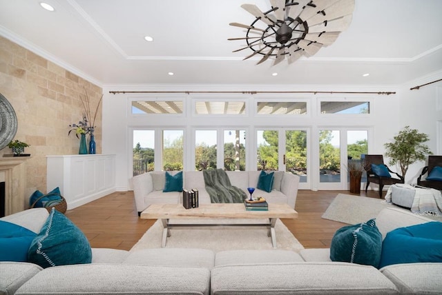 living room with hardwood / wood-style flooring, ornamental molding, a fireplace, and french doors