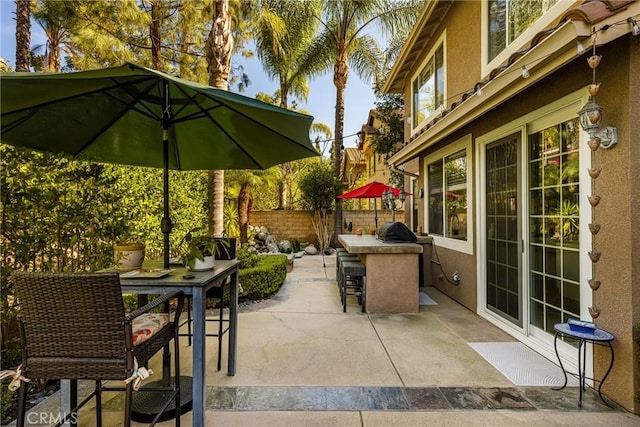 view of patio with fence, outdoor dry bar, and an outdoor kitchen
