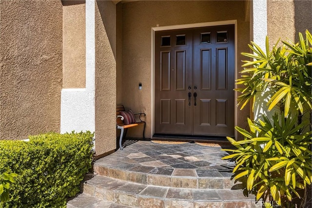 entrance to property featuring stucco siding