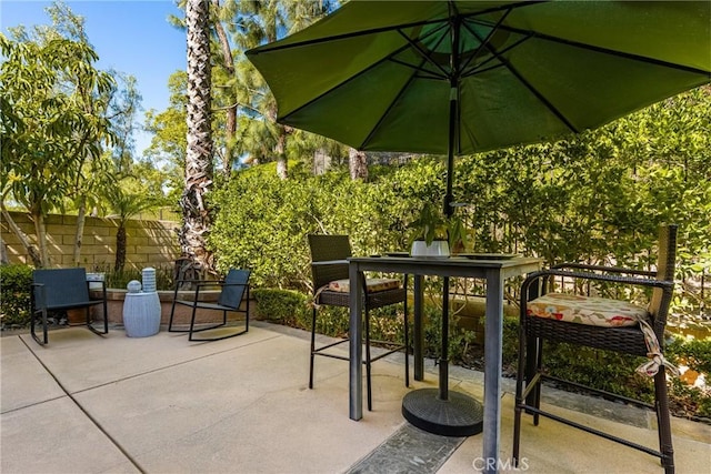 view of patio with outdoor dining area and fence