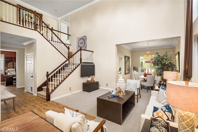 living room with stairway, baseboards, a towering ceiling, and ornamental molding