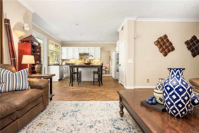 living area with baseboards, wood finished floors, and crown molding