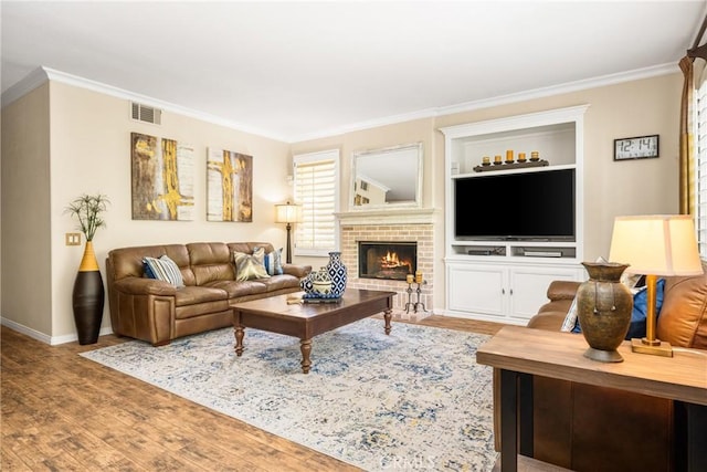 living area featuring ornamental molding, baseboards, wood finished floors, and a fireplace
