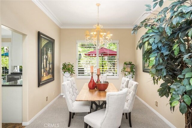 dining room featuring carpet flooring, a notable chandelier, baseboards, and ornamental molding