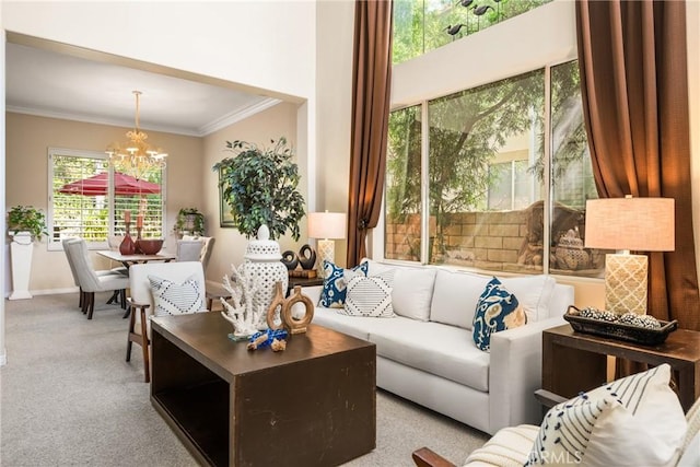 carpeted living area featuring a notable chandelier, ornamental molding, and baseboards