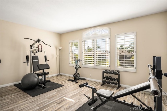 exercise area featuring wood finished floors and baseboards