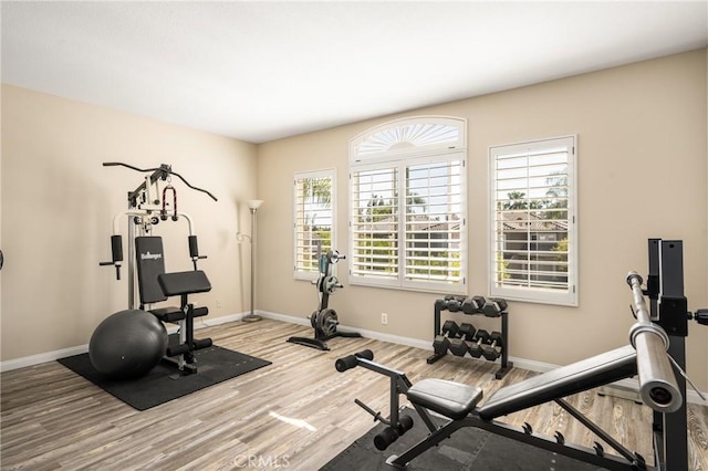 workout room with baseboards and wood finished floors
