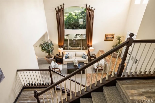 stairs with a high ceiling and wood finished floors