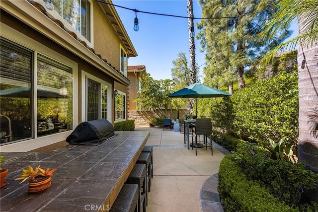 view of patio featuring area for grilling and fence