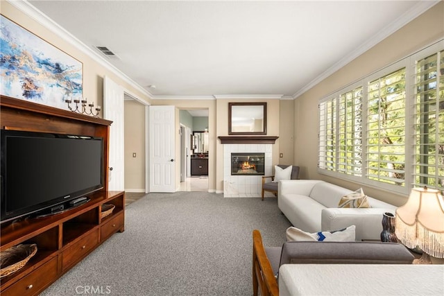 carpeted living room featuring a fireplace, visible vents, baseboards, and ornamental molding