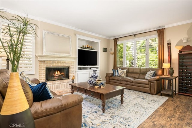 living area featuring crown molding, hardwood / wood-style flooring, and a brick fireplace