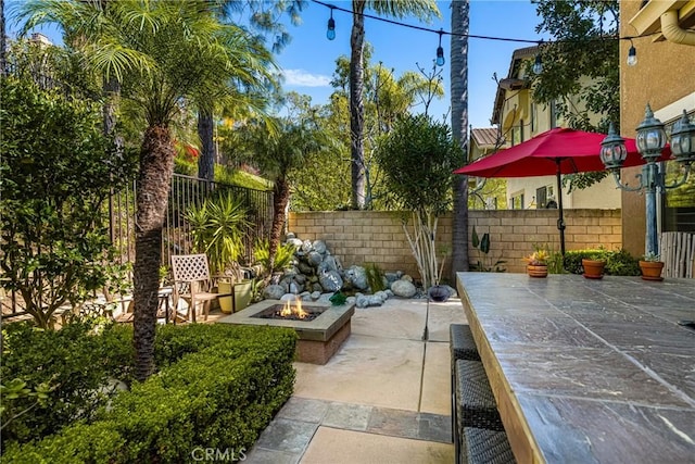 view of patio featuring a fire pit and fence