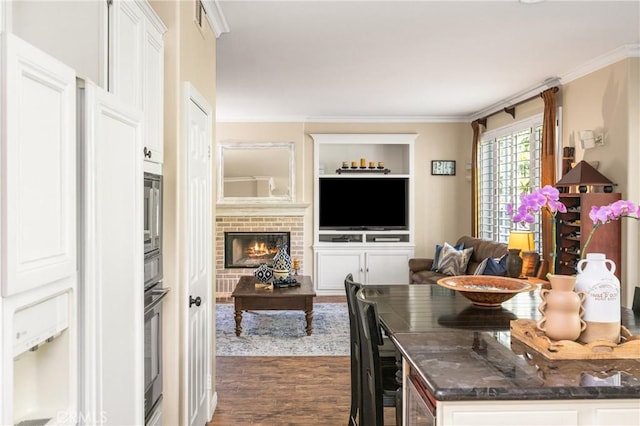 interior space with white cabinets, open floor plan, dark wood-style flooring, and ornamental molding