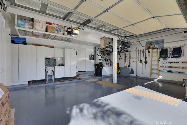 garage featuring freestanding refrigerator and a garage door opener