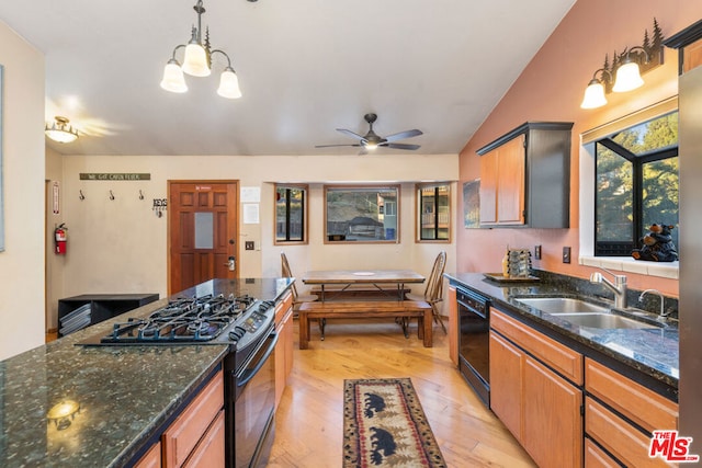 kitchen with black appliances, sink, light hardwood / wood-style floors, lofted ceiling, and decorative light fixtures