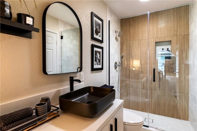 bathroom with vanity, toilet, and an enclosed shower