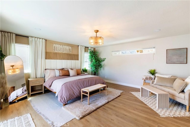 bedroom featuring wood-type flooring and a chandelier