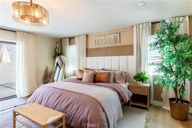 bedroom with access to outside and light wood-type flooring