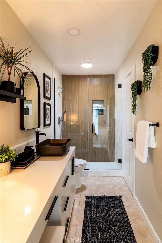 bathroom with tile patterned flooring, vanity, toilet, and a shower with shower door