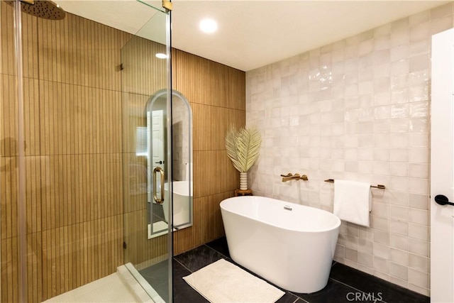 bathroom with tile patterned flooring, independent shower and bath, and tile walls