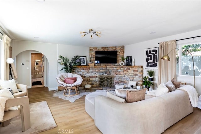 living room with light hardwood / wood-style flooring and a stone fireplace