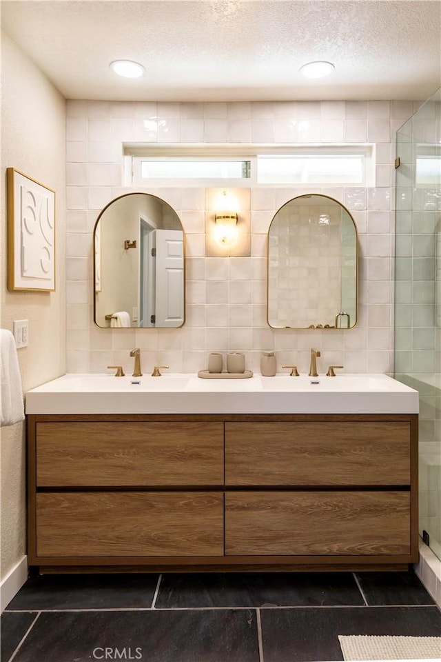 bathroom with vanity, tile patterned floors, tile walls, walk in shower, and a textured ceiling