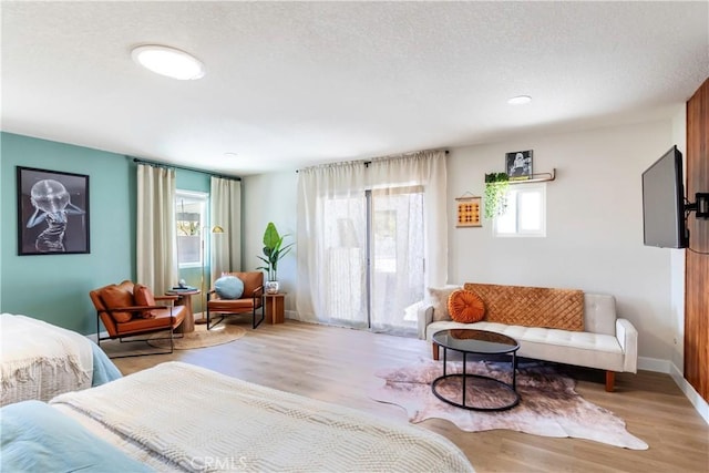 bedroom with light wood-type flooring and a textured ceiling