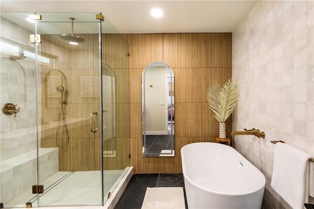 bathroom with tile patterned floors, tile walls, and independent shower and bath