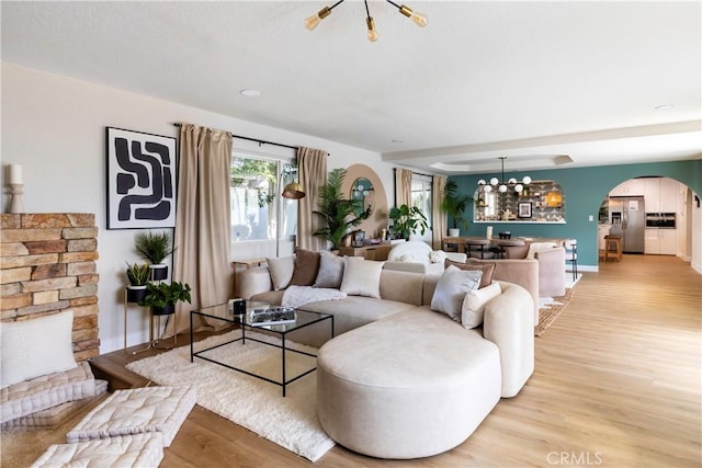 living room with light hardwood / wood-style floors and a notable chandelier