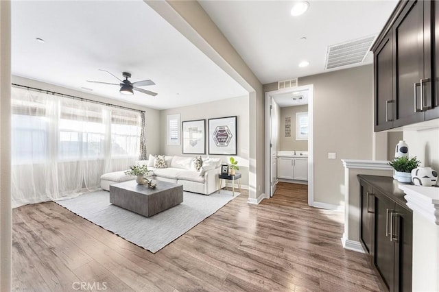 living room featuring ceiling fan and light hardwood / wood-style floors